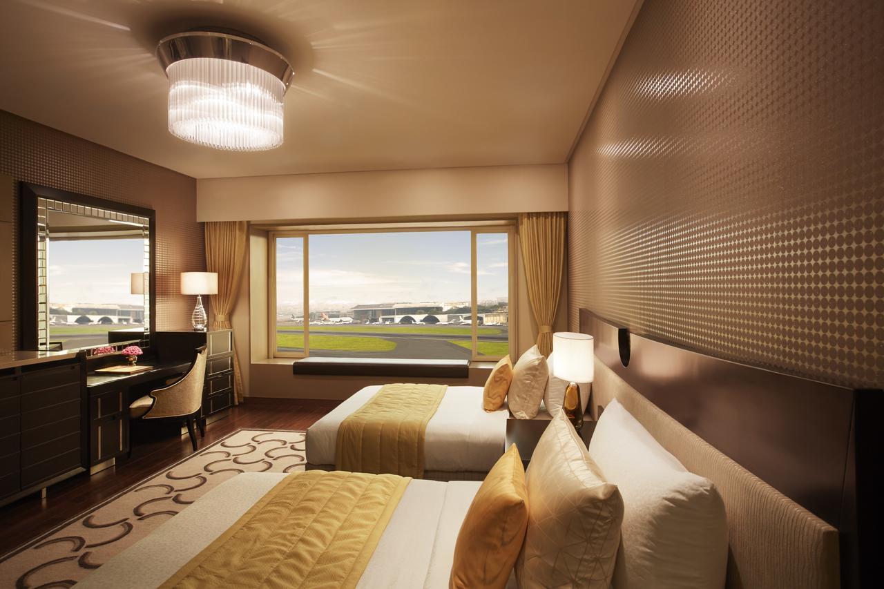 Luxuriöses Zweibettzimmer mit Badewanne und Blick auf die Landebahn
